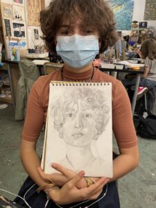A boy holding a sketch of his own