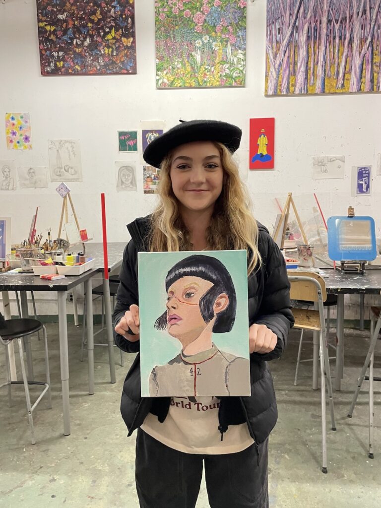 A girl with her wonderful painting of a woman