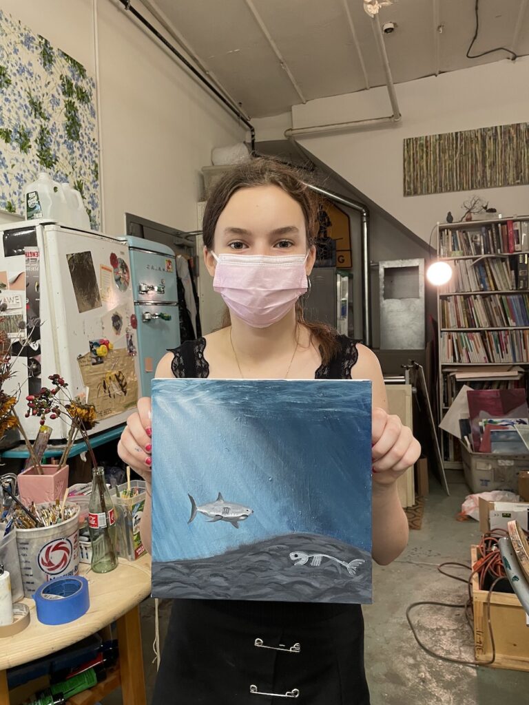 A girl showing her painting of the sea world