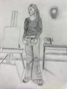 A woman standing in front of an easel.