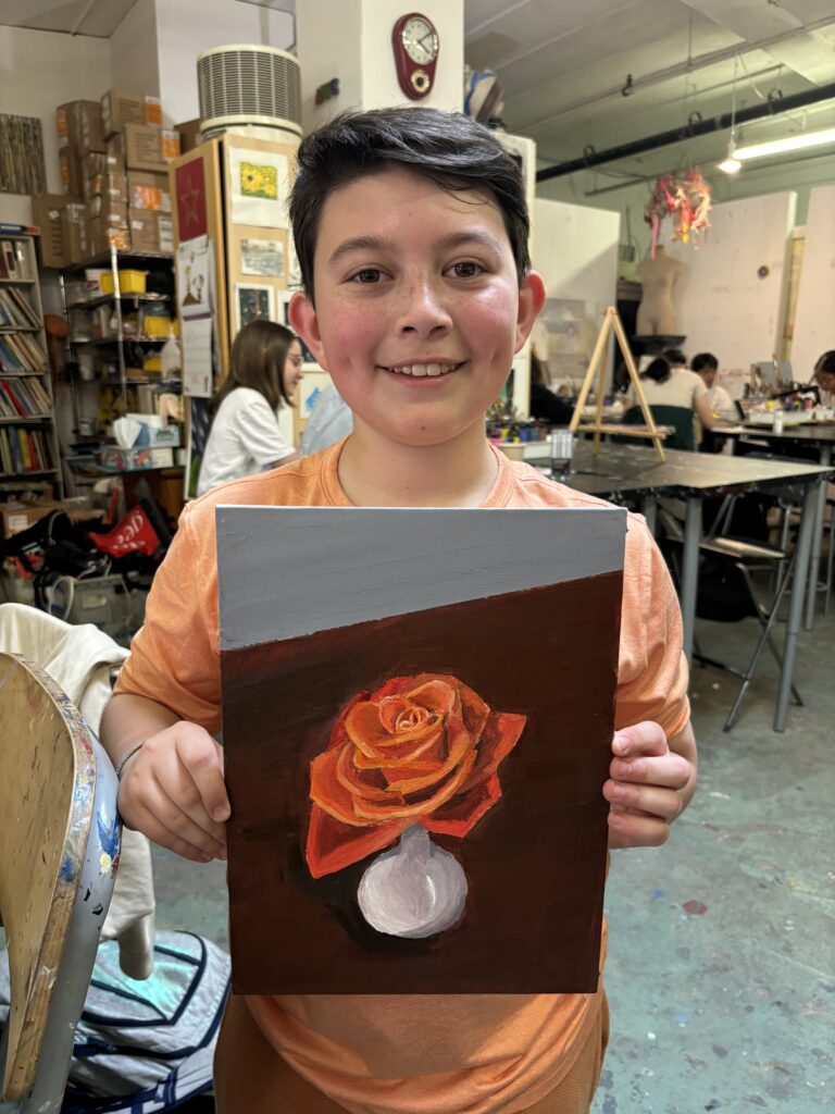 A boy holding up an image of a rose.