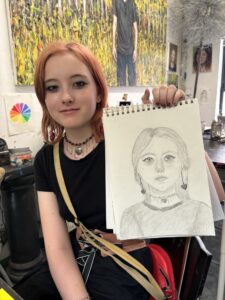 A girl holding up an image of herself.