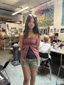 A girl standing in front of some tables and chairs