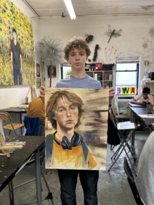 A boy holding up an image of himself.