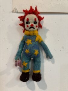 A clown doll with red hair and yellow face.