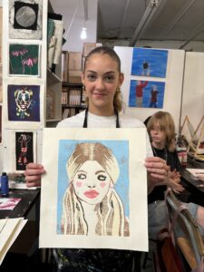 A girl holding up a picture of herself