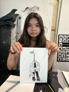 A girl holding up an image of a giraffe.