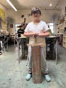 A boy standing in front of some tables and chairs