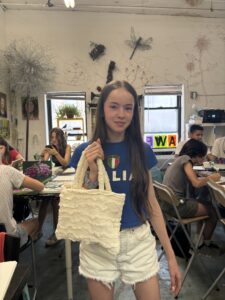A girl holding a bag in front of other people.