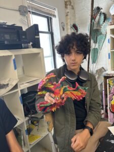 A man holding onto some colorful paper cranes