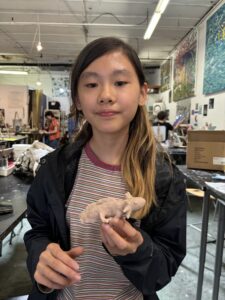 A girl holding a small animal in her hands.