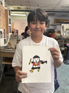 A boy holding up an image of a penguin.