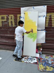 A man painting on the side of a building.