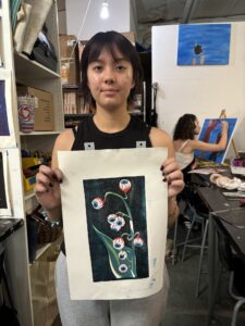 A woman holding up a picture of flowers.