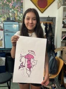 A girl holding up an umbrella drawing.
