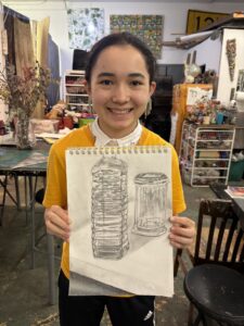 A girl holding up an image of a tower.