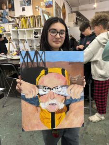 A woman holding up an image of a person with glasses.
