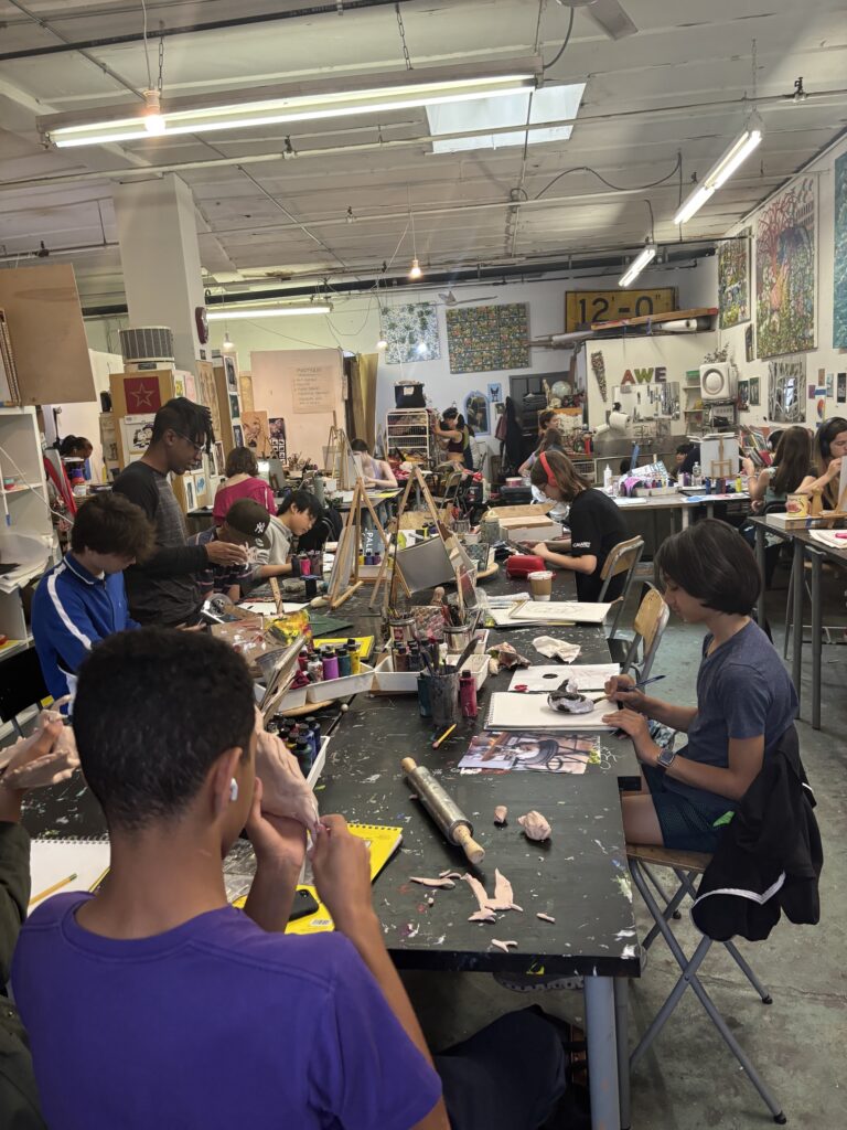 A group of people sitting at tables working on paper.