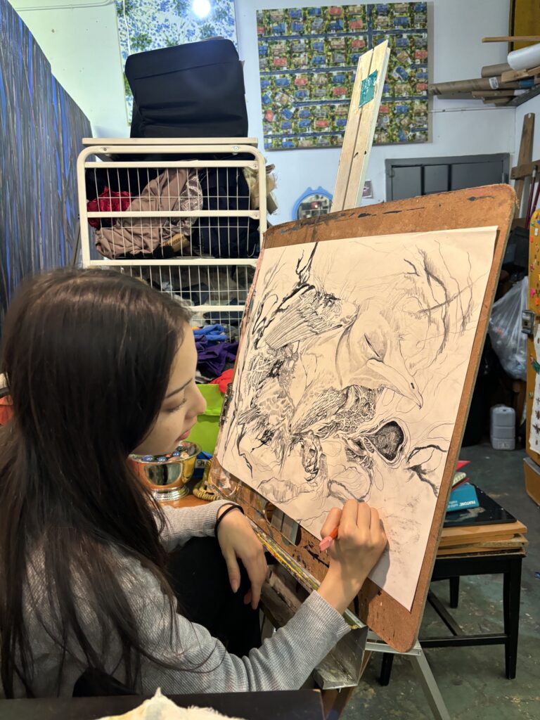 A woman is painting on an easel in her studio.