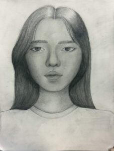 A pencil drawing of a young woman with long hair.