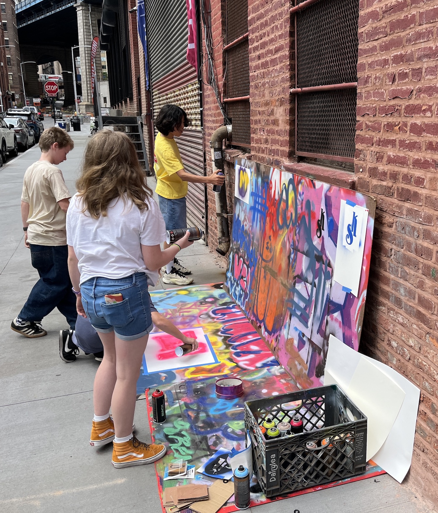 A group of kids painting on the side walk