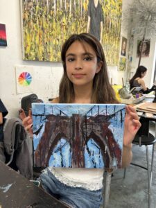 Girl holding bridge painting artwork.