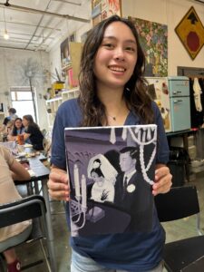 Girl holding painted wedding portrait.