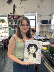 Girl holding Kate Bush portrait drawing.