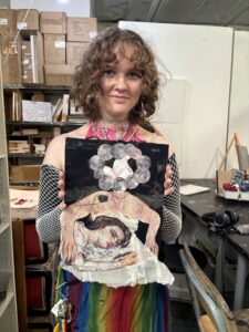 Person holding mixed-media artwork.