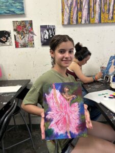 Girl holding painting of ballerina.