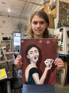 Girl holding painting of woman with cards.