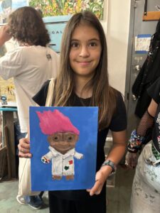 Girl proudly displays her troll painting.