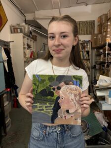 Woman holding painted portrait of family.