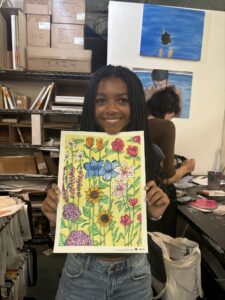 Girl proudly displays her colorful flower art.