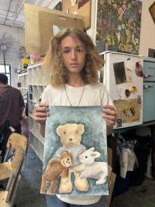 Teen showing stuffed animal watercolor painting.