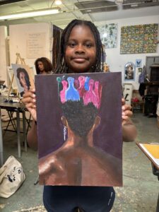 Girl proudly displays her painted artwork.