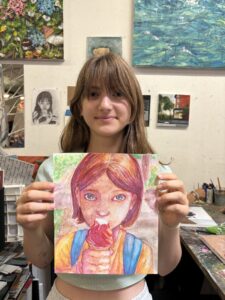 Girl proudly displays her pastel drawing.