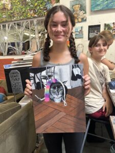 Girl proudly displays her cat painting.