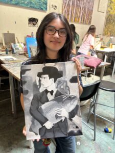 Girl holding grayscale painting of man and fish.
