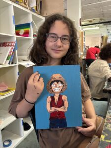 Girl holding Luffy painting.