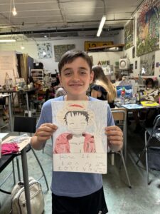 Boy holding drawing of Luffy, One Piece.