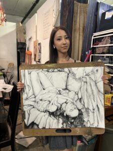 Student displays charcoal figure drawing.