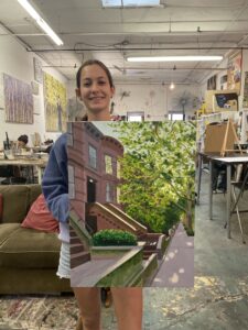 Woman holding painting of brownstone steps.