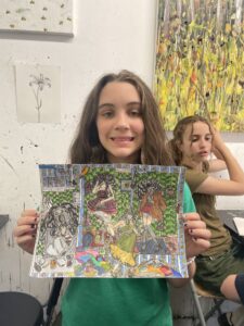 Girl proudly displays her colorful artwork.