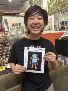 Smiling child holding robot art print.