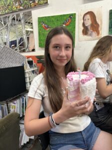 Girl holding a sculpted birthday cake.