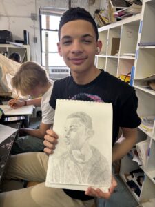 Teen showing off his pencil portrait.