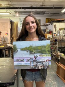 Girl holding river landscape painting.