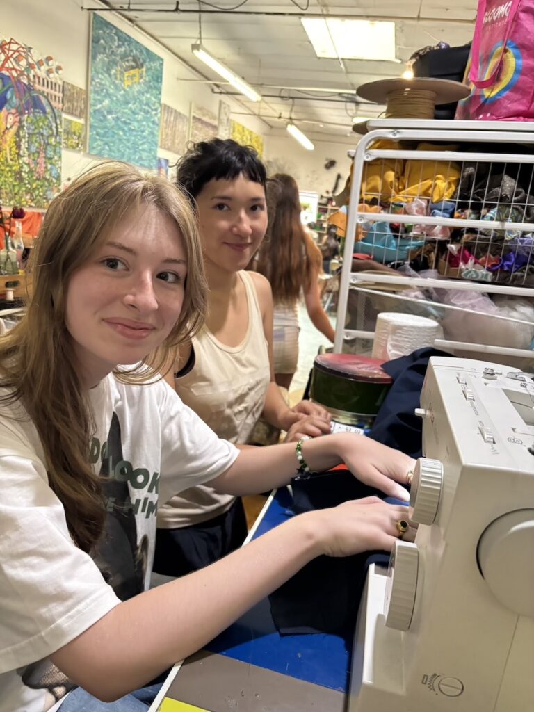 Two women enjoying sewing together in a colorful craft room.