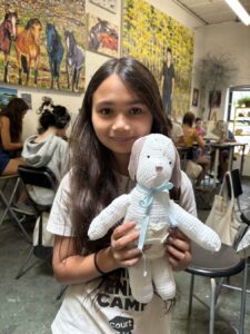 A girl holding a stuffed bunny in a cozy cafe.